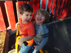 Two children smiling and laughing together on the playground